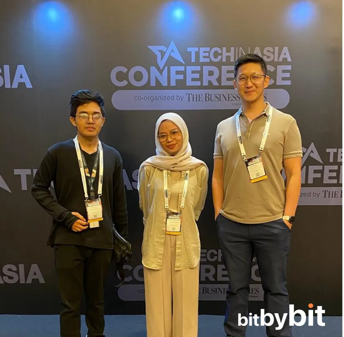 Three bitbybit team members in front of the Tech in Asia 2025 Conference backdrop in Jakarta
